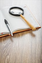 Pen and magnifying glass on the notebook