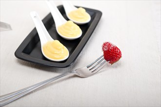 Custard pastry cream and strawberry on a fork