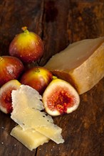 Italian pecorino cheese and fresh figs macro closeup over old wood boards