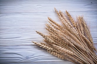 Bunch of wheat rye ears on wooden board food and drink concept