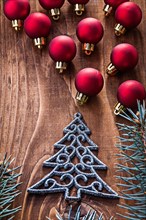 Small Christmas fir trre and large composition of small red baubles on old wooden board