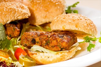Four fresh and delicious mini chicken burgers on a plate