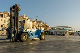 Forklift lowers a boat into the water at a marina