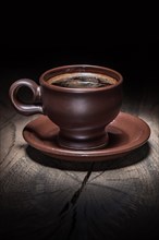 Brown clay coffee cup on vintage wood