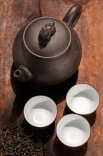 Chinese green tea traditional pot and cups over old wood board