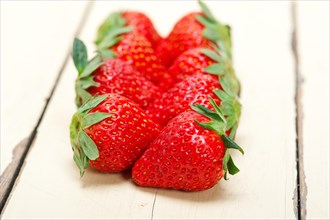 Fresh organic strawberry over white rustic wood table