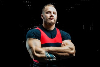 Huge powerlifter stands in front of the camera and strains his huge hands.
