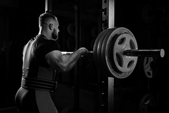Professional athlete prepares to squat with a barbell.