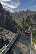 Hikers enjoy the view from a platform in a mountain range