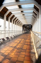 Long straight corridor with concrete structure and railings in symmetrical view