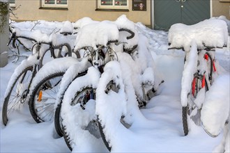 Snow-covered bicycles with fresh snow