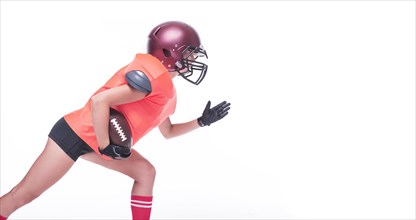 Woman in the uniform of an American football team player prepares to run with the ball. White background. Sports concept.