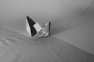 A simple paper boat in origami style on a monochrome background