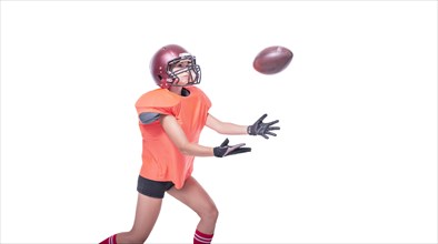 Woman in the uniform of an American football team player catches the ball. White background. Sports concept.