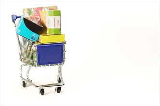 Shopping cart full of boxes of grocery items isolated on a white background