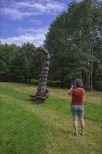 Woman photographing a wooden scorpion figure