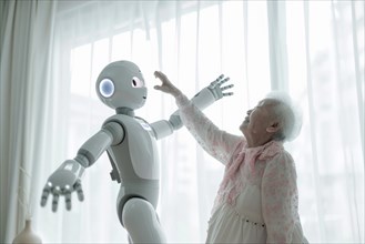 Elderly woman dancing and having fun with a cute white care robot