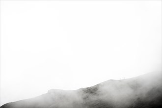 Mountaineer on a mountain ridge in the fog