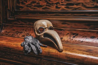 Abstraction of a venetian mask of a doctor lying on the piano keys. Concept of epidemic