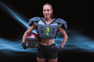 Portrait of a sportive girl in the uniform of an American football team player. Sports concept. Futuristic background.
