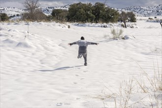 Boy running and enjoying the snowy landscape