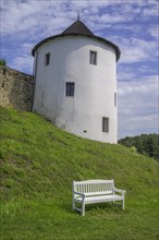 Tower of the fortified village and white bench