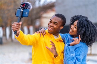 Two young african bloggers recording a video in the street