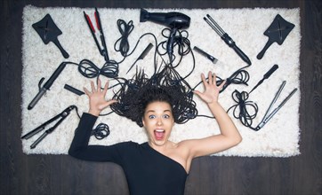 The charming girl spread her hands to the side and screams. Against the backdrop of the tools for creating a haircut