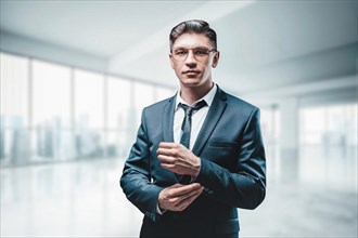 Portrait of a businessman in a suit. He is standing in the office of a skyscraper. Business concept.