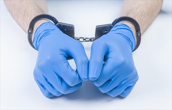 Hands of a doctor in handcuffs. The concept of corruption in medicine.