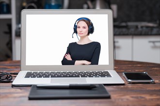 Image of a laptop with a splash screen that depicts a woman with headsets. Customer support concept.