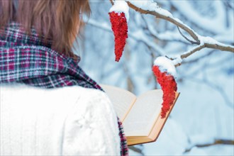 The girl reads a book in the winter forest. Learning concept. Winter's tale.