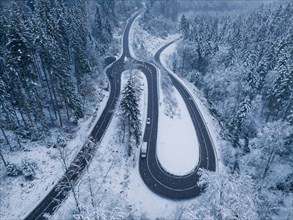 Drone image of a winter roundabout surrounded by snow-covered trees