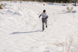 Young man having fun running in big snow