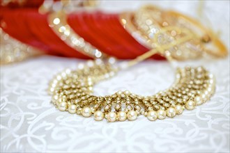 Close-up of an elegant golden pearl necklace with a bokeh background