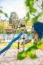 Colourful climbing frame with slide on a playground surrounded by nature