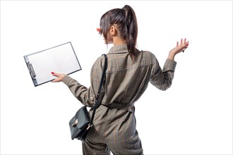 Portrait of a woman in a life style suit with a tablet and a white sheet in her hand. Back view. Business concept.