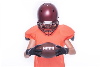Woman in the uniform of an American football team player posing with a ball on a white background. Sports concept.