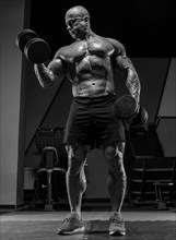 Professional weightlifter is training in the gym. Dumbbell Curl. Bodybuilding concept.