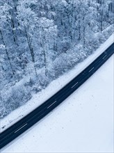 Drone image of a road surrounded by snow in a wintry environment