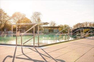 Outdoor swimming pool at sunset with clear water and railings