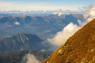 Aerial View over Beautiful Mountainscape with Clouds and Lake Lugano and City of Lugano in a Sunny Day in Ticino
