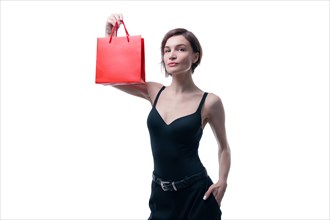 Beautiful young woman holding a craft red package in her hand. Shopaholics concept. Spenting. Gifts for the holidays. Black Friday. Shopping centers