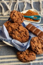 Chocolate chunk cookies beside brown sugar and a chocolate bar