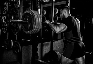 Professional athlete prepares to squat with a barbell.