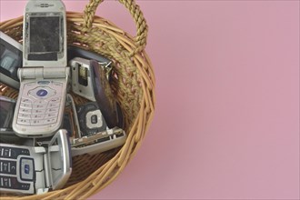 Old mobile phones spilling from a basket