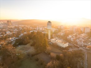 Elevated view of a water tower and the cityscape at sunrise