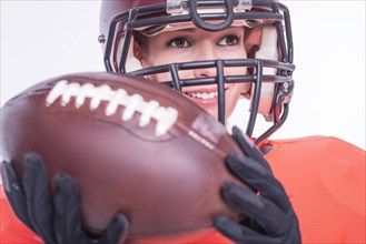 Portrait of a smiling girl in the uniform of an American football team player. White background. Sports concept.