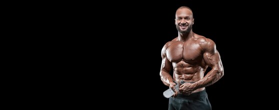 Isolated muscular man on a black background. Bodybuilding and fitness concept. Panorama.