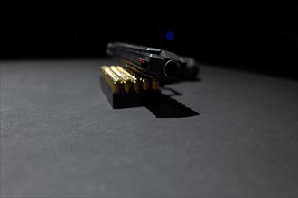 Modern Elegant Handgun Leaning on Munition Bullet on Grey Background in Switzerland